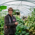 Horticultural Therapist Julia standing amongst plants in polytunnel